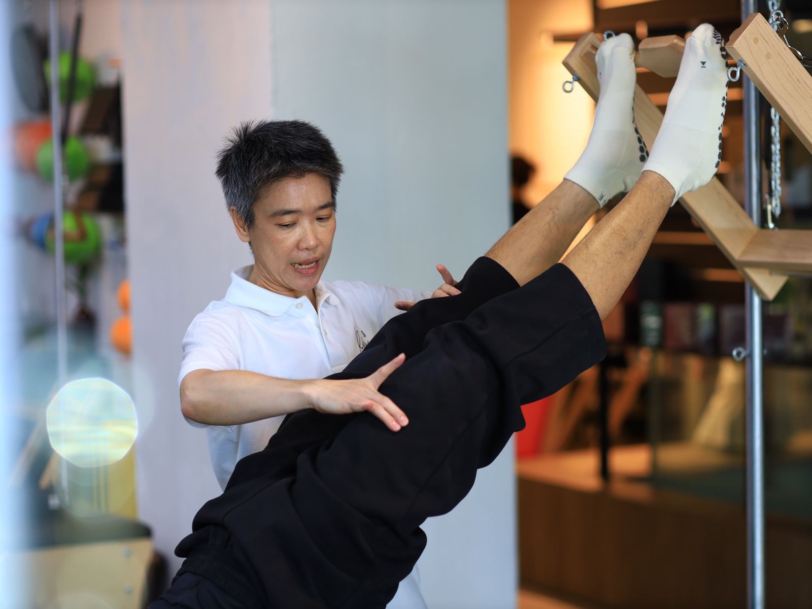 Kru Golf supporting a student in side-bend on the Spine Corrector
